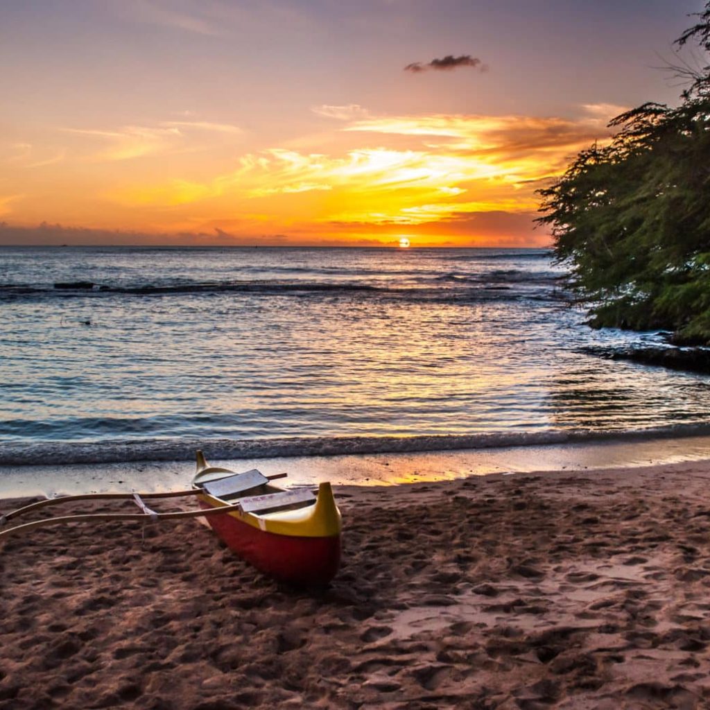 A beautiful sunset at a Luau in Hawai'i - with canoe sitting on beach