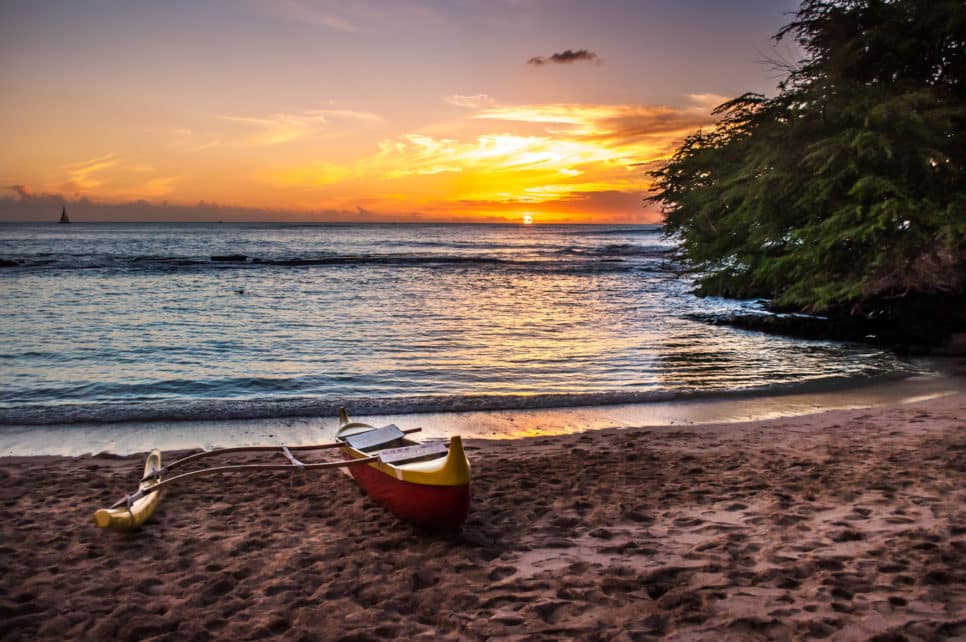 A beautiful sunset at a Luau in Hawaii - with canoe sitting on beach